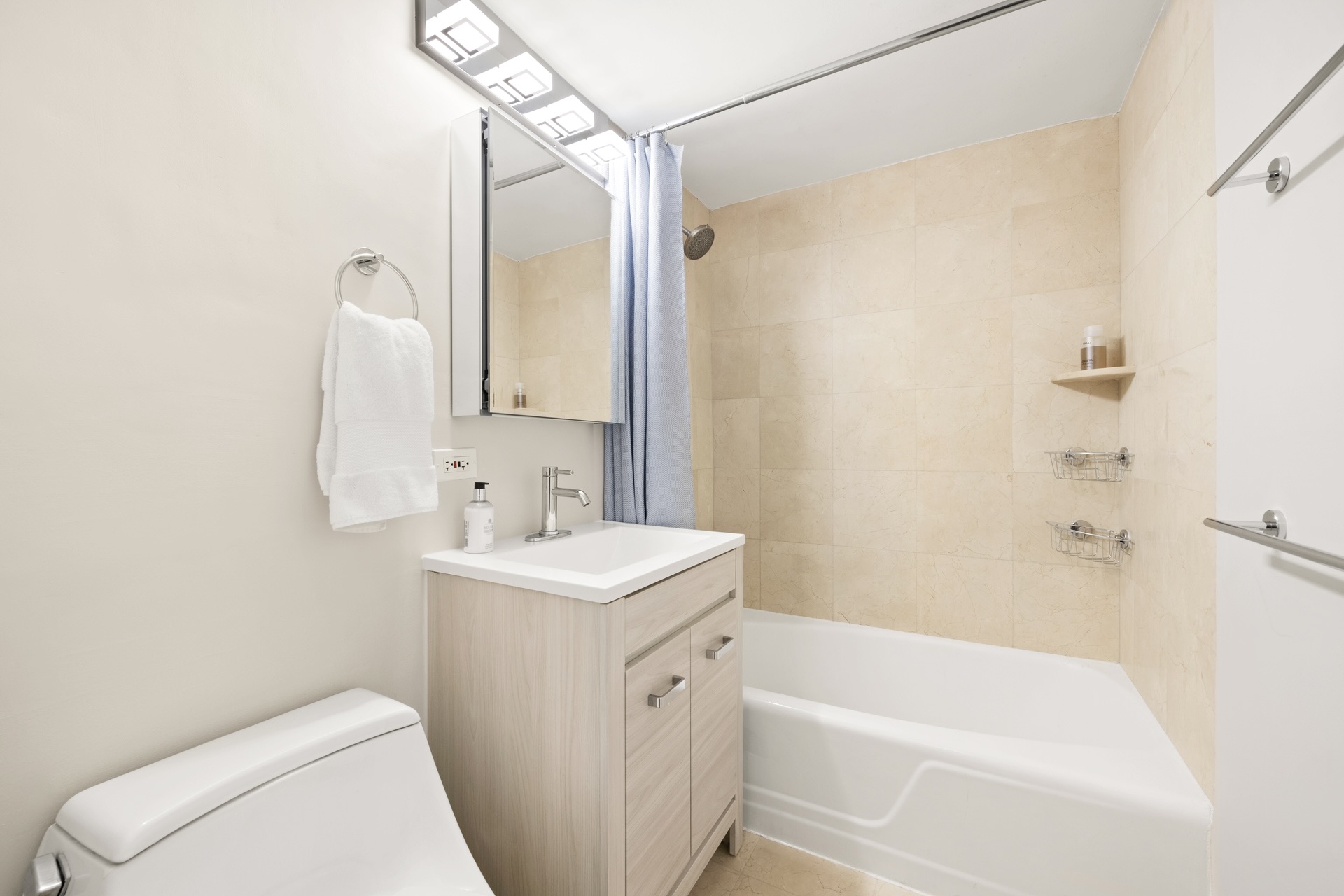 200 East 58th Street, Unit 10J Manhattan, NY 10022 - Photo 6 of 8 a bathroom with a sink a toilet and shower