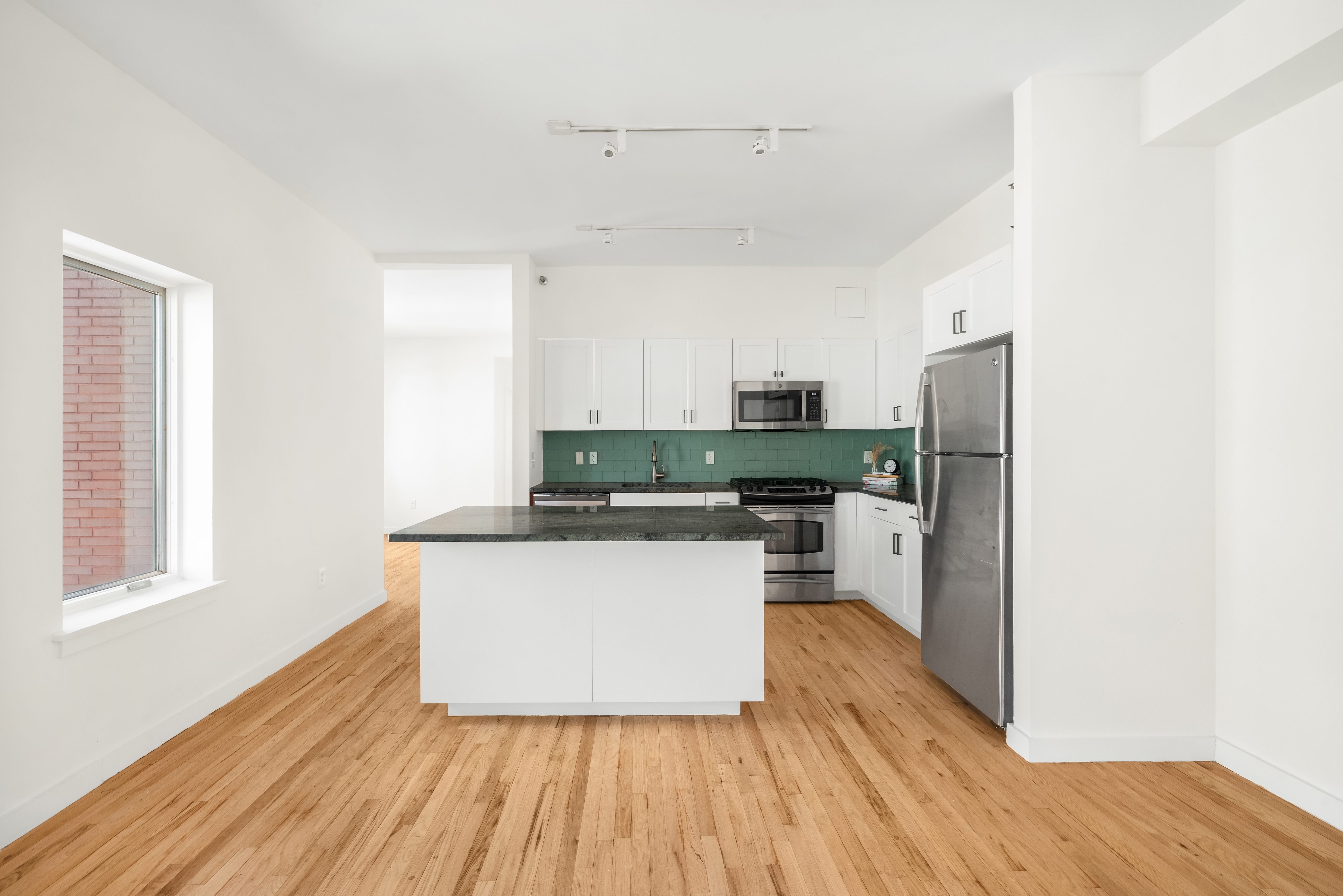 304 West 115th Street, Unit 6A Manhattan, NY 10026 - Photo 5 of 14 a kitchen with stainless steel appliances wooden floors and refrigerator