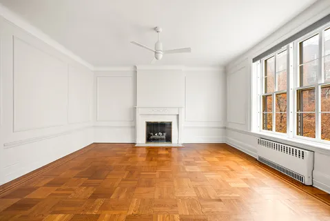 a view of an empty room with a fireplace and a window