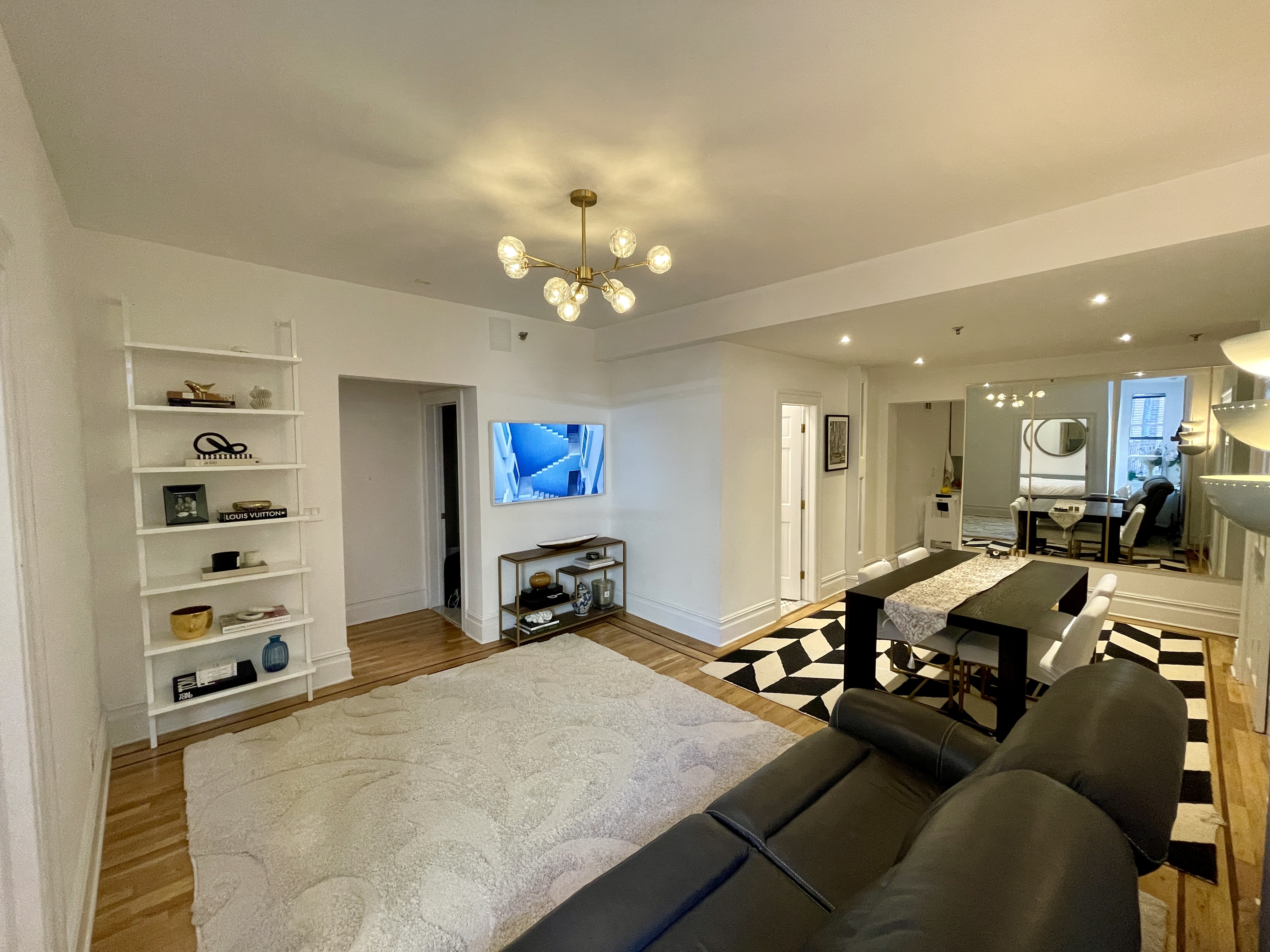 a living room with furniture a chandelier and a dining table