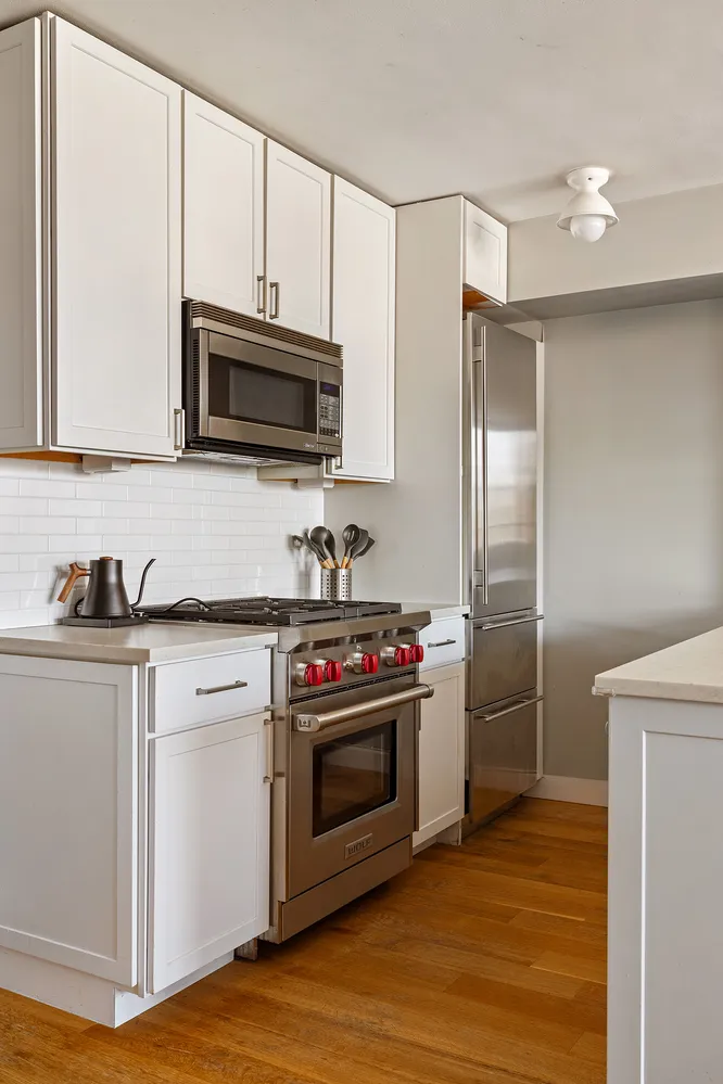 a kitchen with stainless steel appliances a stove a microwave and a sink