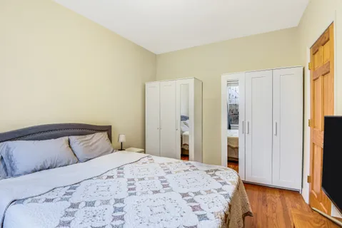 a bedroom with a bed and wooden floor