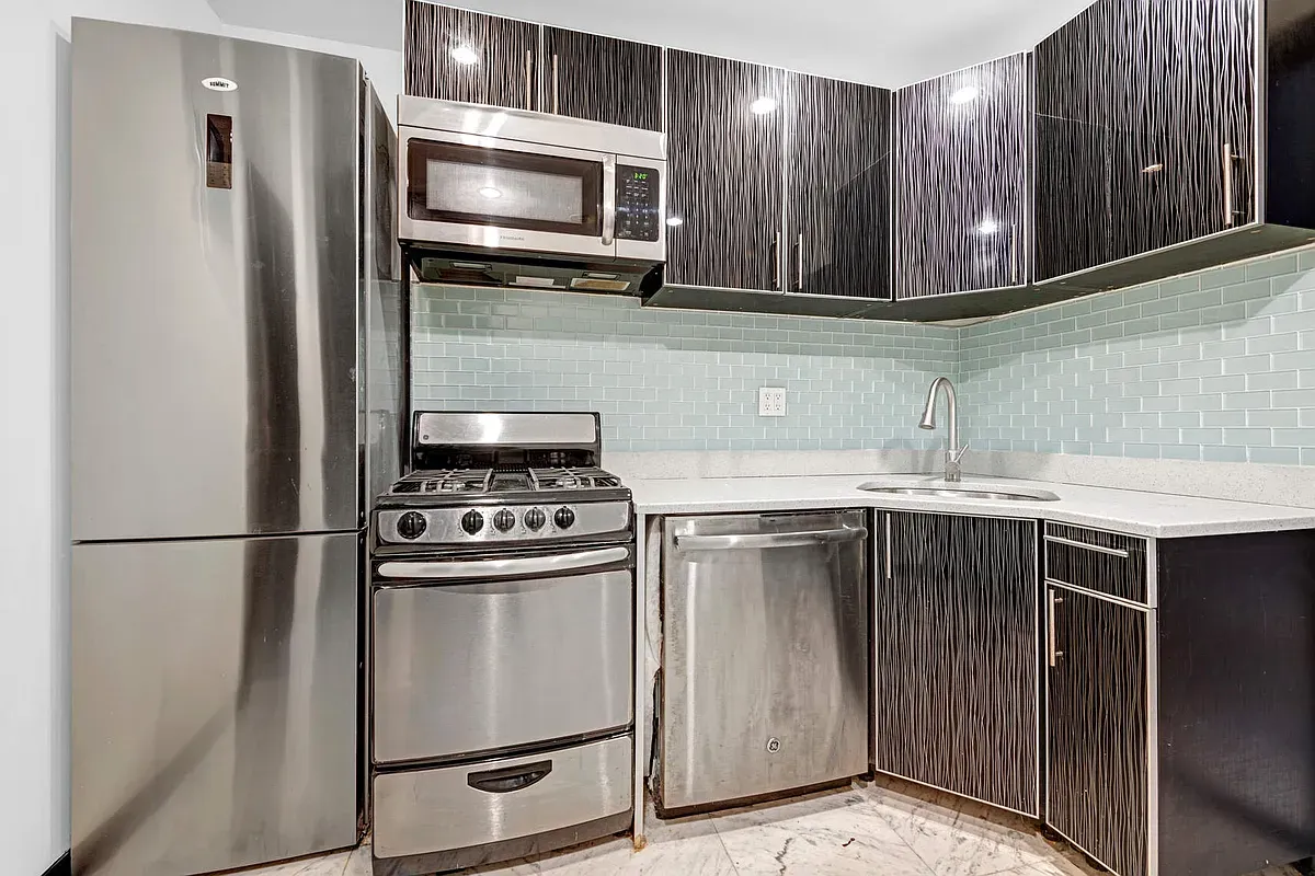 a kitchen with stainless steel appliances granite countertop a sink stove and refrigerator