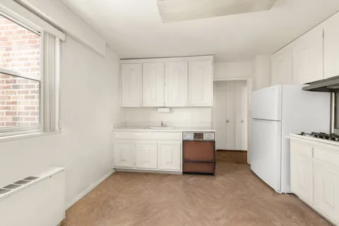 a kitchen with white cabinets and white appliances