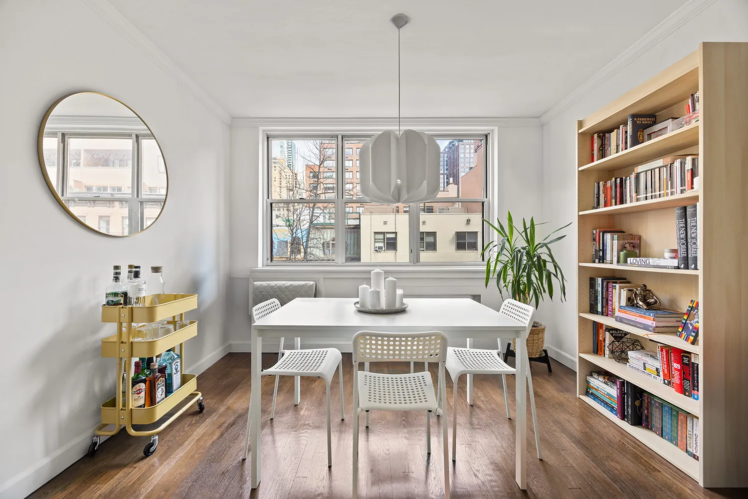 a view of a dining room with furniture a book and wooden floor