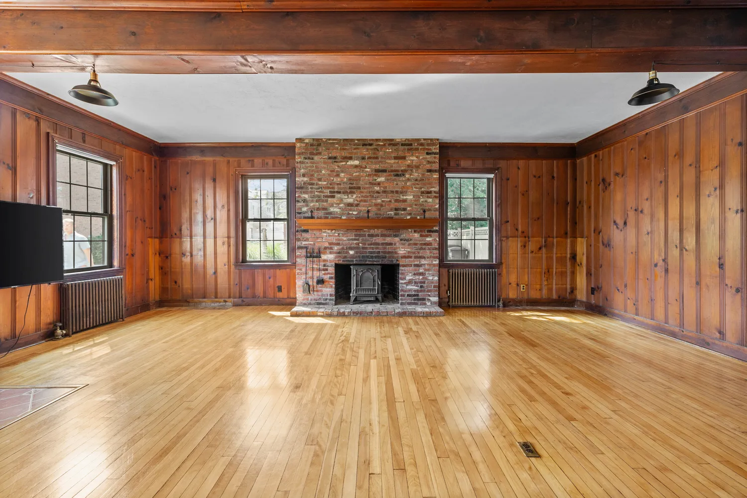 wooden floor fireplace and windows in an empty room