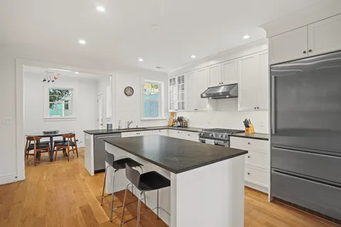 a kitchen with stainless steel appliances granite countertop a sink a stove and a refrigerator