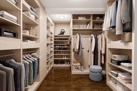 a view of walk in closet with clothes and shoes