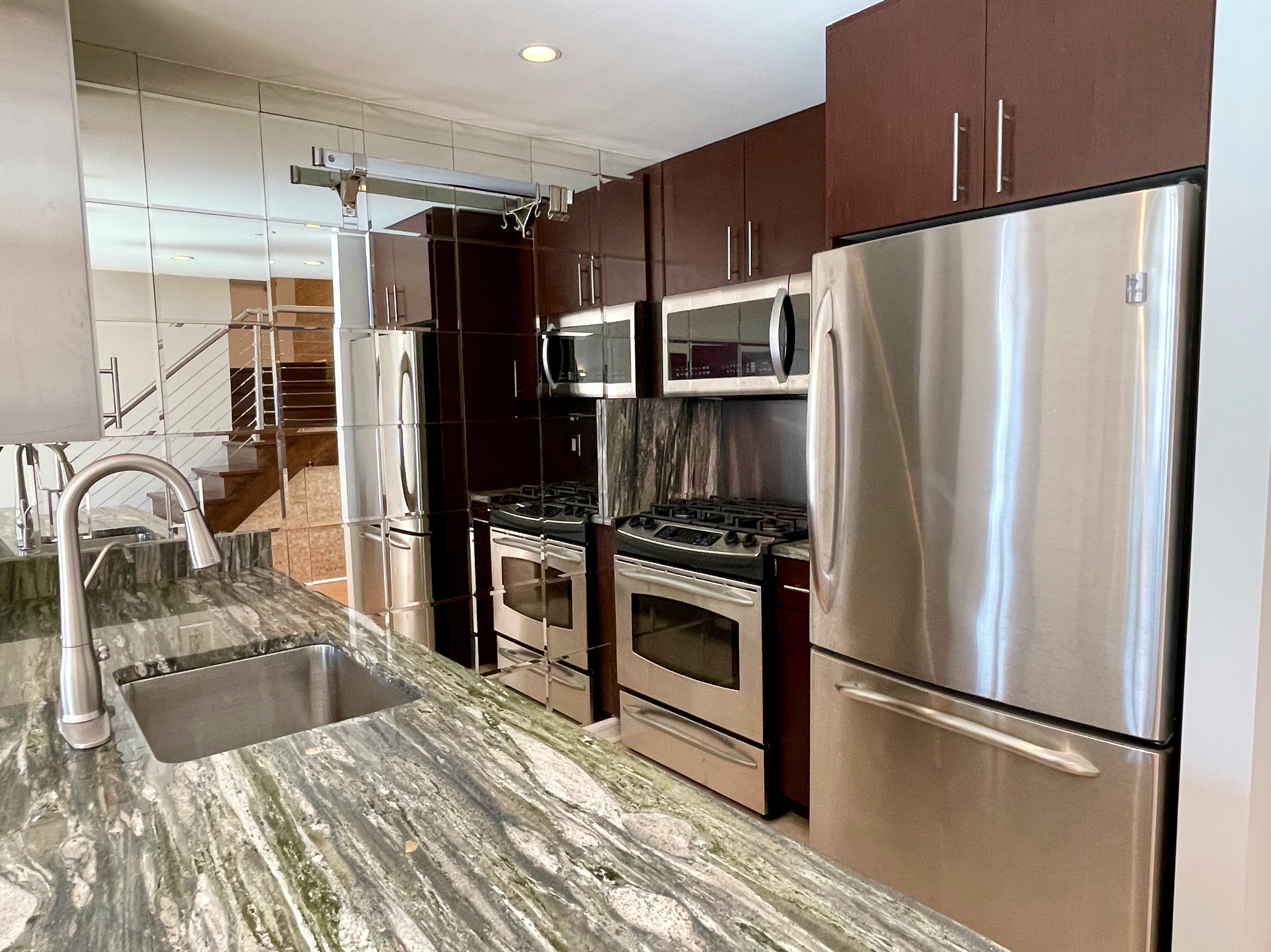 350 West 53rd Street, Unit PHA Manhattan, NY 10019 - Photo 8 of 35 a kitchen with granite countertop a refrigerator and a sink
