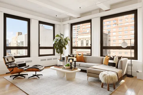 a living room with furniture and floor to ceiling windows