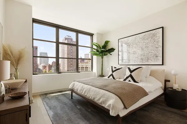 a bedroom with a bed and a large window