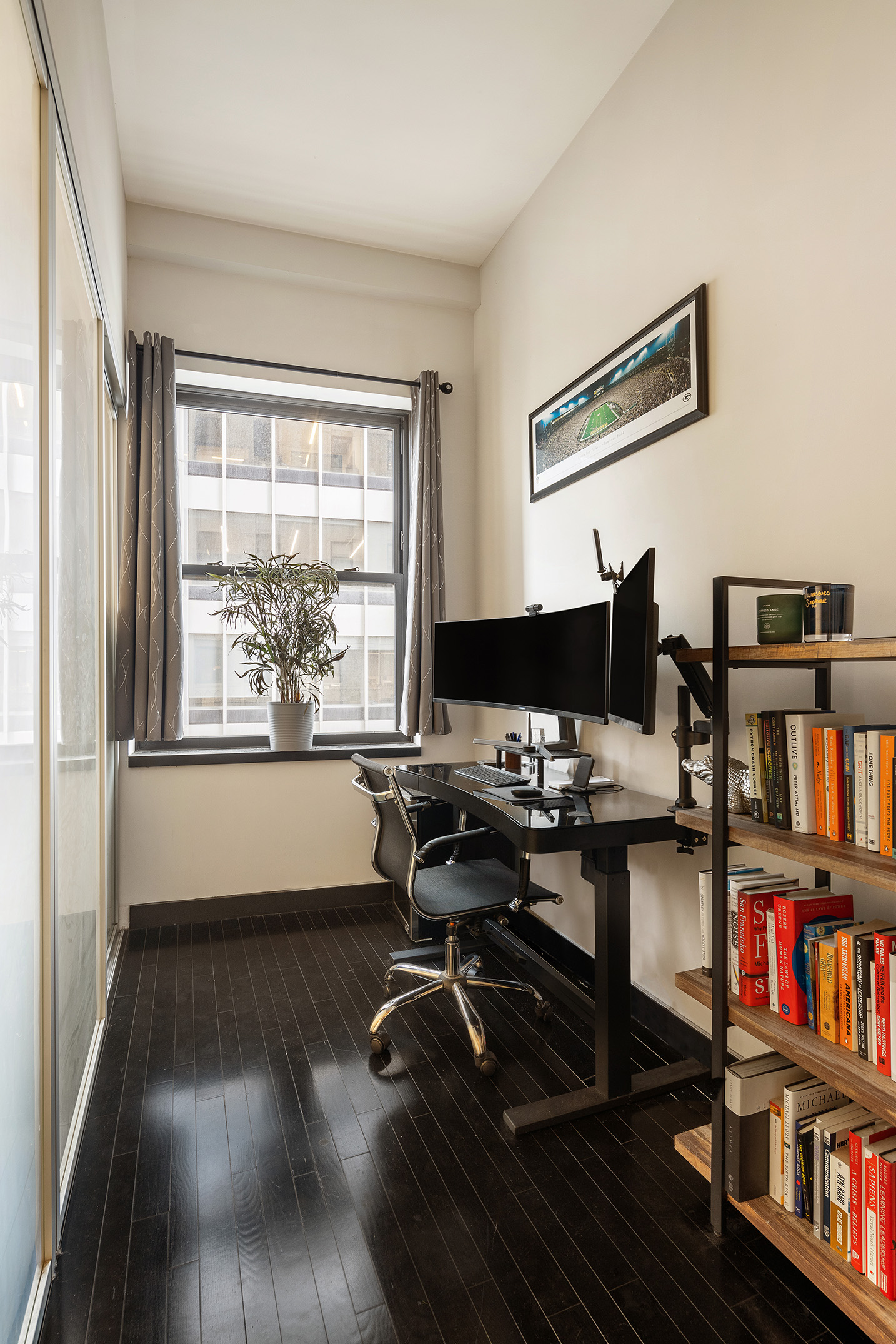 20 Pine Street, Unit 2413 Manhattan, NY 10005 - Photo 6 of 16 a view of a workspace with furniture and a bookshelf