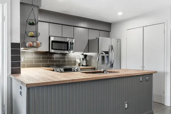 a kitchen with kitchen island a sink stainless steel appliances and cabinets