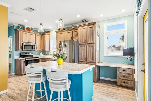 a kitchen with kitchen island granite countertop a sink appliances cabinets and counter space