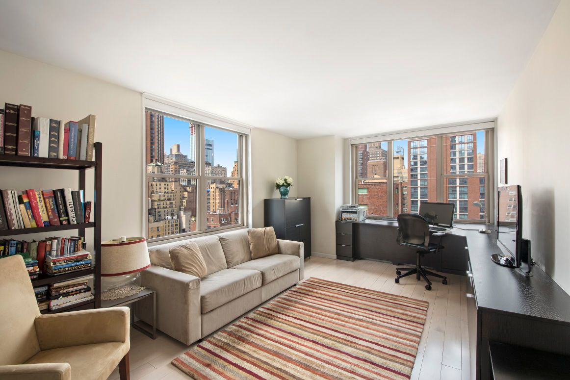 a living room with furniture and a book shelf