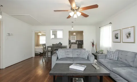 a living room with furniture and a wooden floor