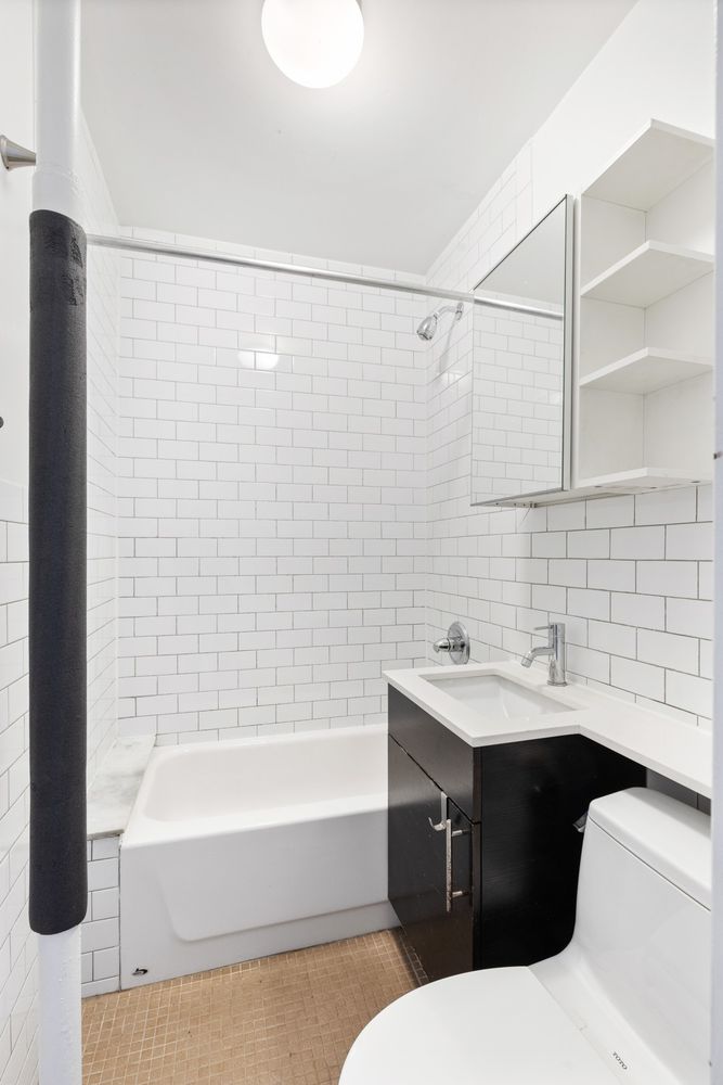 9 Spring Street, Unit 24 Manhattan, NY 10012 - Photo 5 of 8 a bathroom with a sink and a bathtub