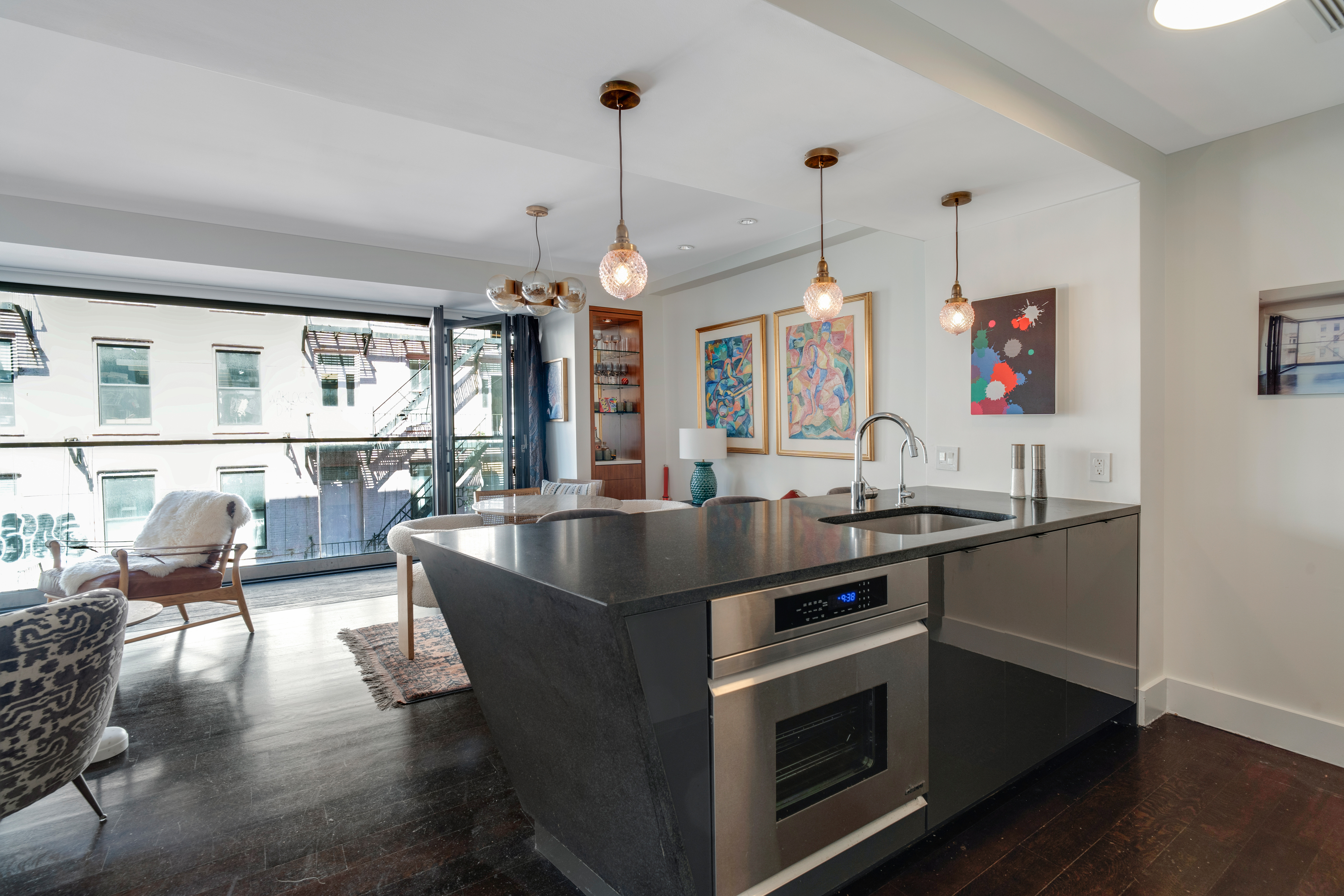 60 Orchard Street, Unit 4 Manhattan, NY 10002 - Photo 13 of 18 a kitchen with stainless steel appliances granite countertop a sink a stove and a wooden floor