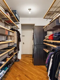 a view of walk in closet with clothes and shoes