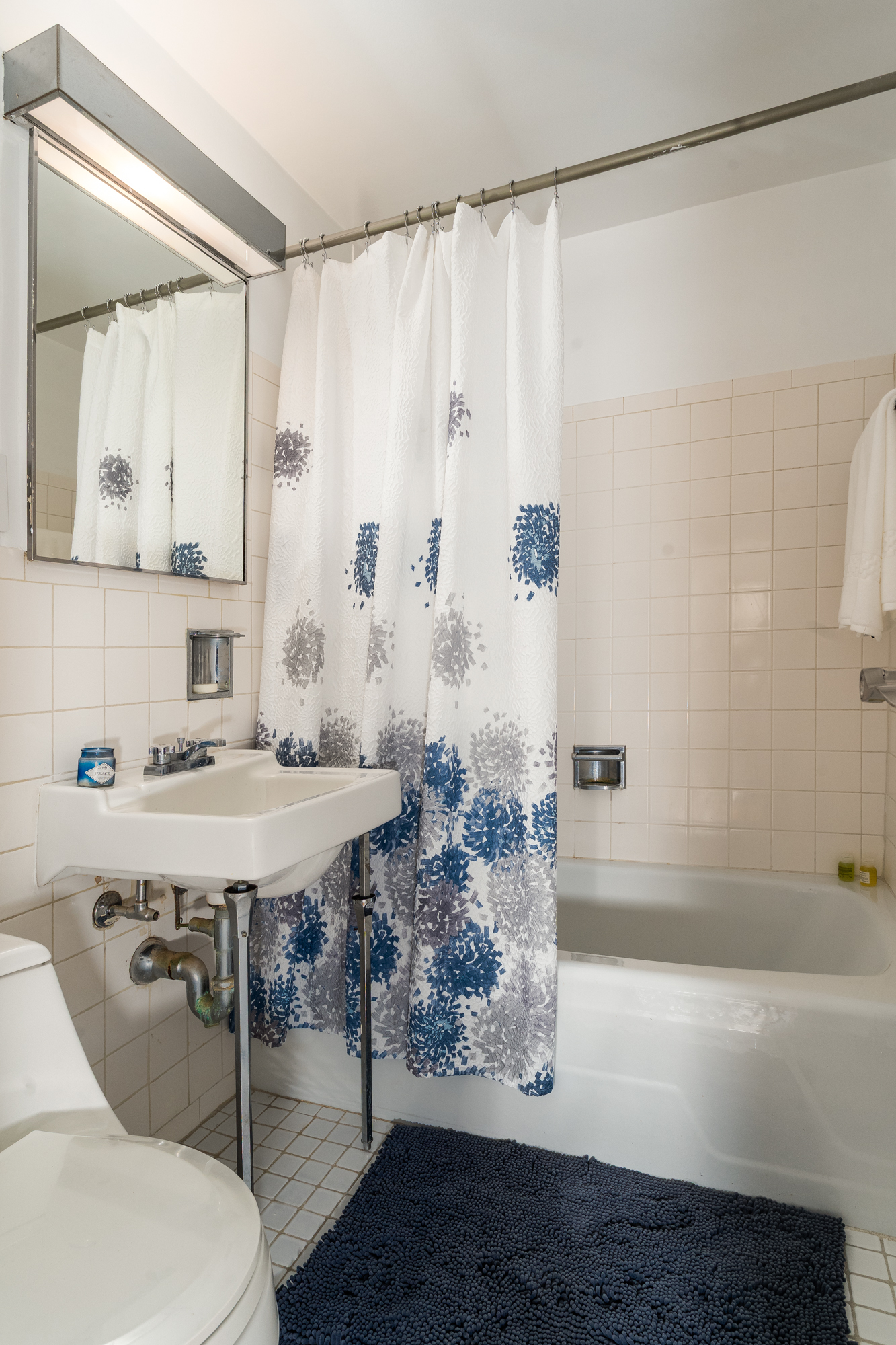 180 West End Avenue, Unit 23D Manhattan, NY 10023 - Photo 13 of 22 a bathroom with a sink and a mirror