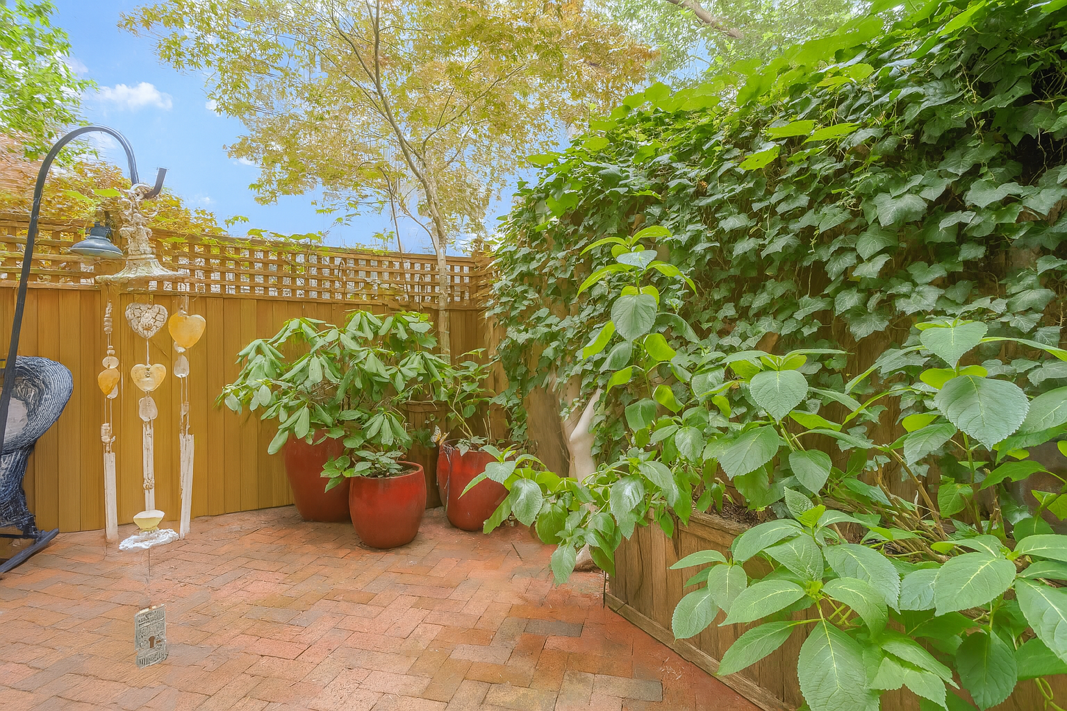 517 East 87th Street, Unit 1 Manhattan, NY 10128 - Photo 15 of 17 a view of a pathway with plants and wooden fence