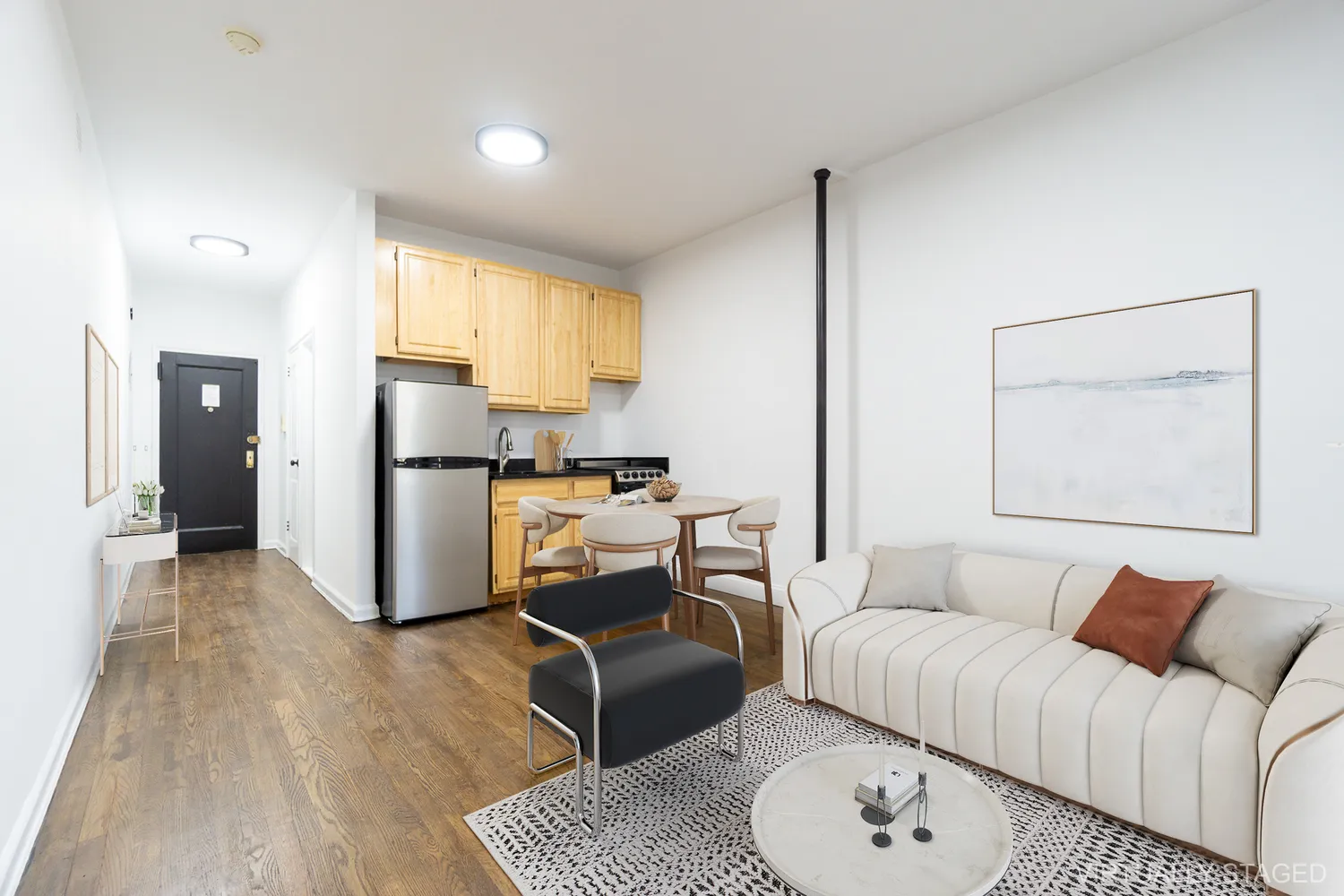 a living room with furniture a refrigerator and wooden floor