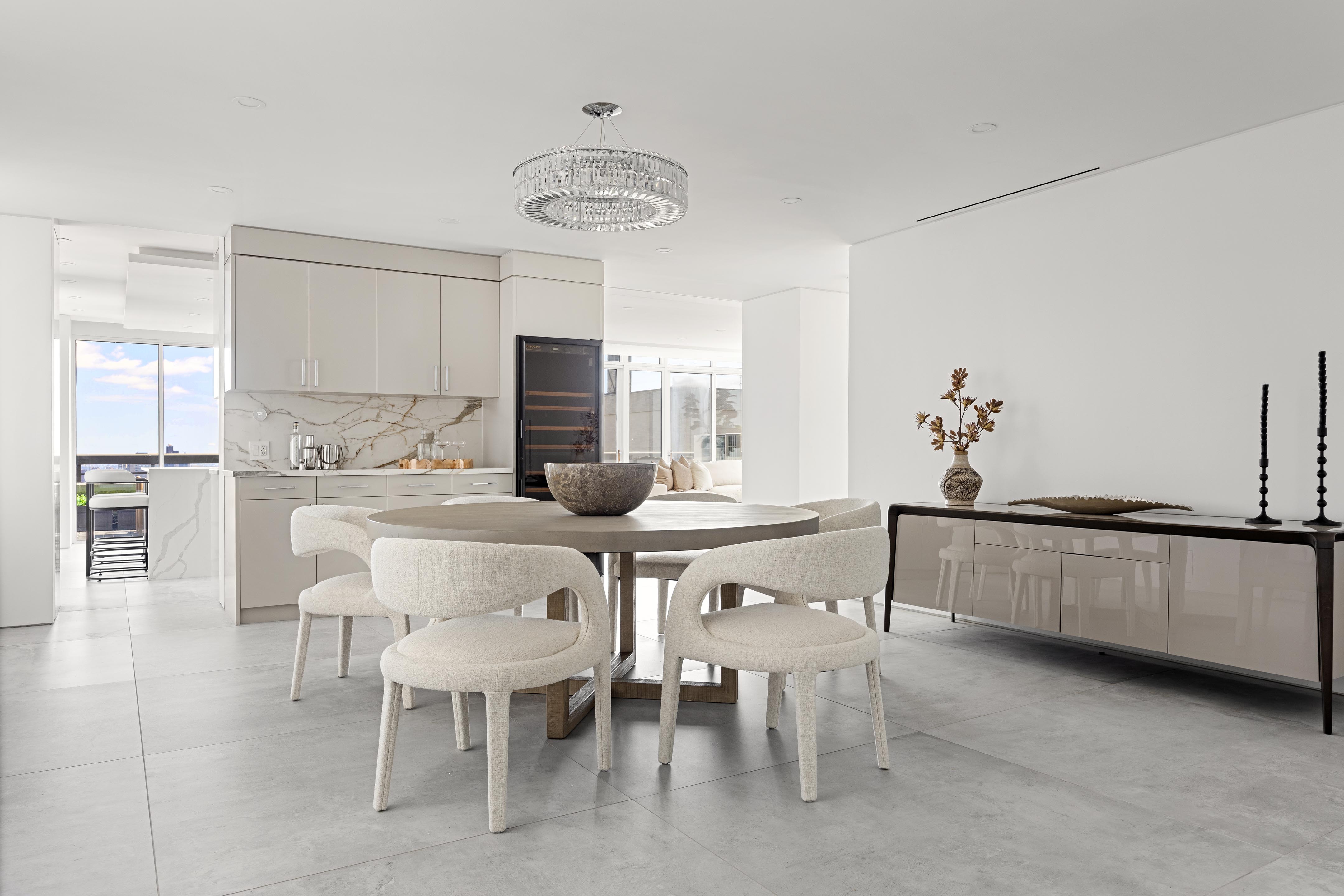 422 East 72nd Street, Unit 37AD Manhattan, NY 10021 - Photo 5 of 38 a kitchen with a dining table chairs and refrigerator