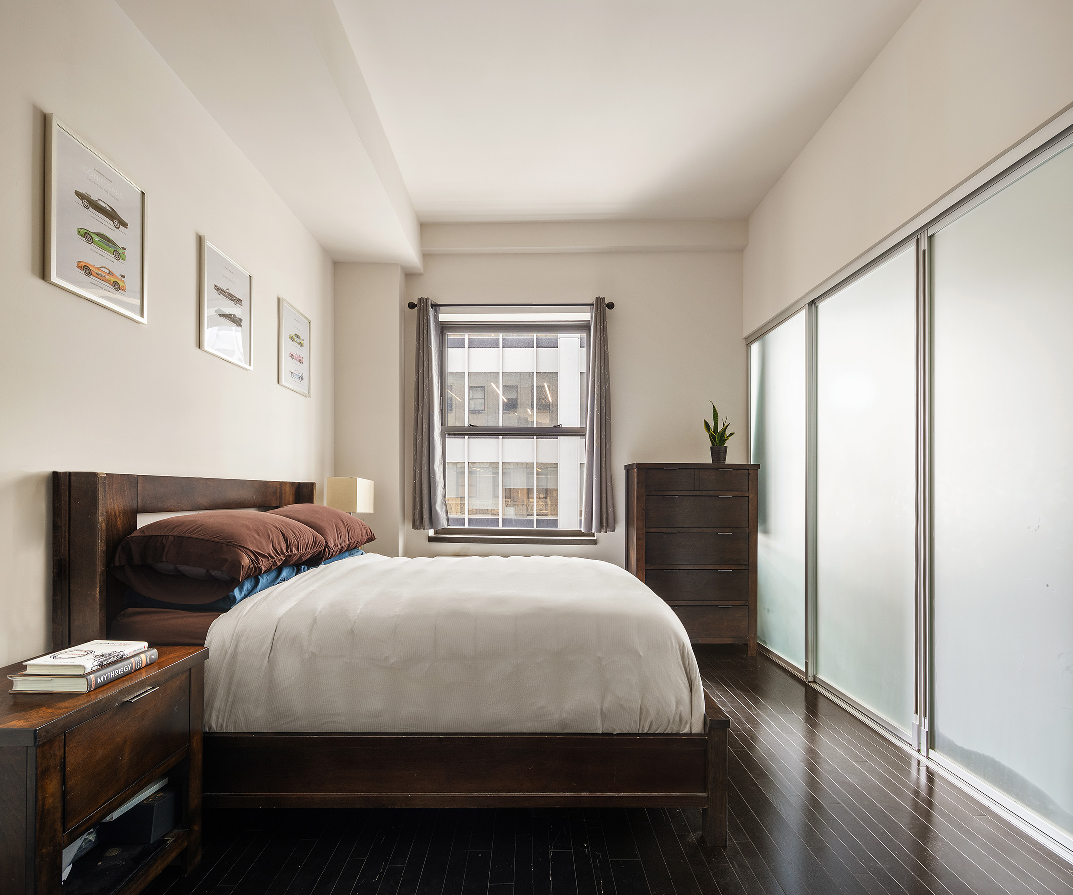 20 Pine Street, Unit 2413 Manhattan, NY 10005 - Photo 5 of 16 a bedroom with a bed and wooden floor