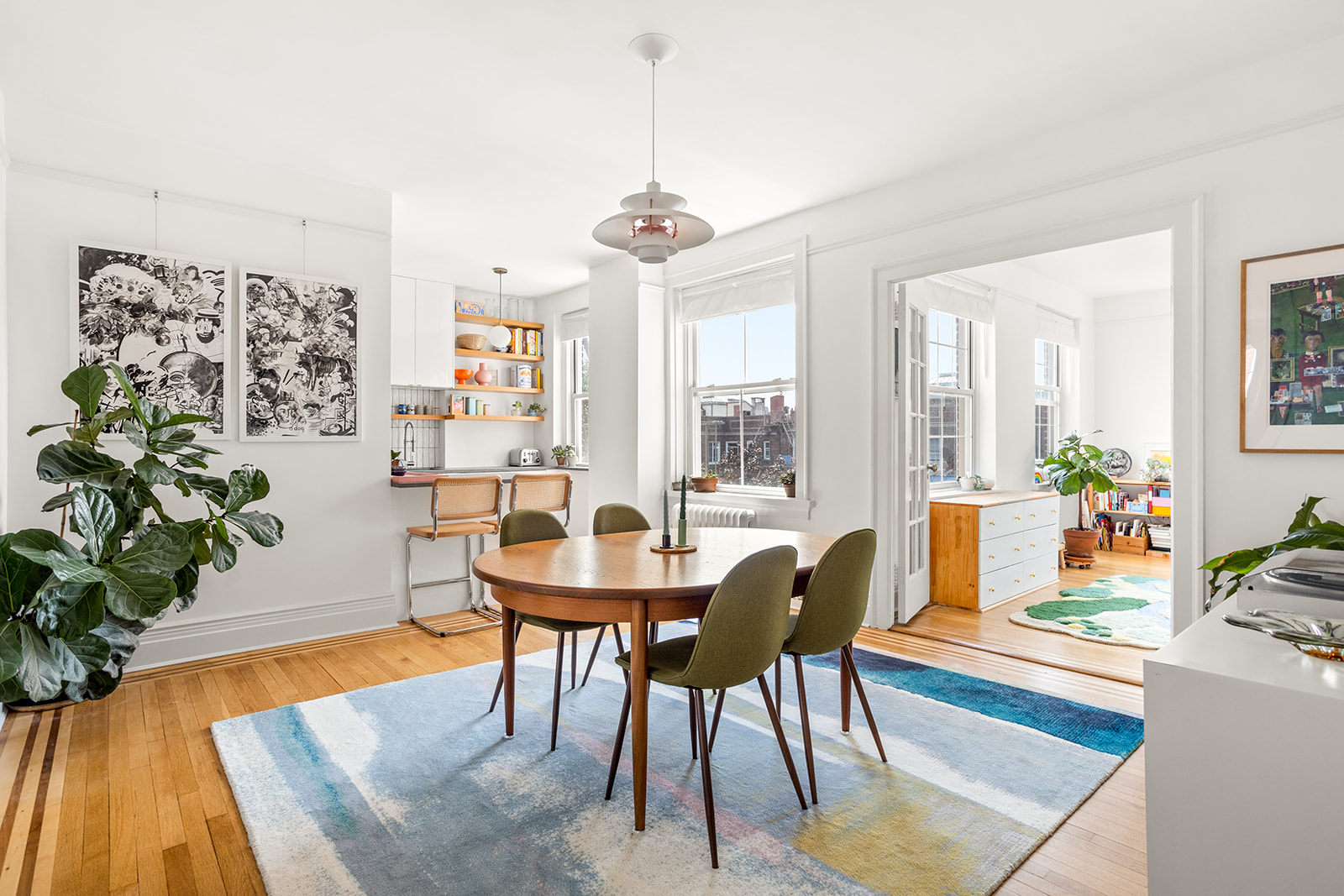 a dining room with furniture potted plants and wooden floor