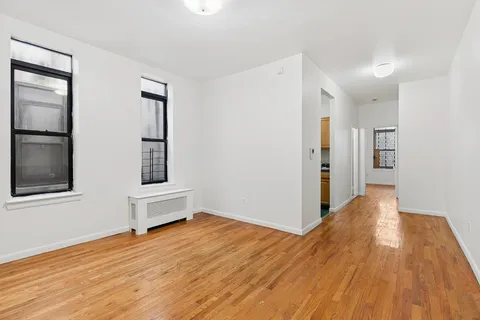 a view of empty room with wooden floor and window