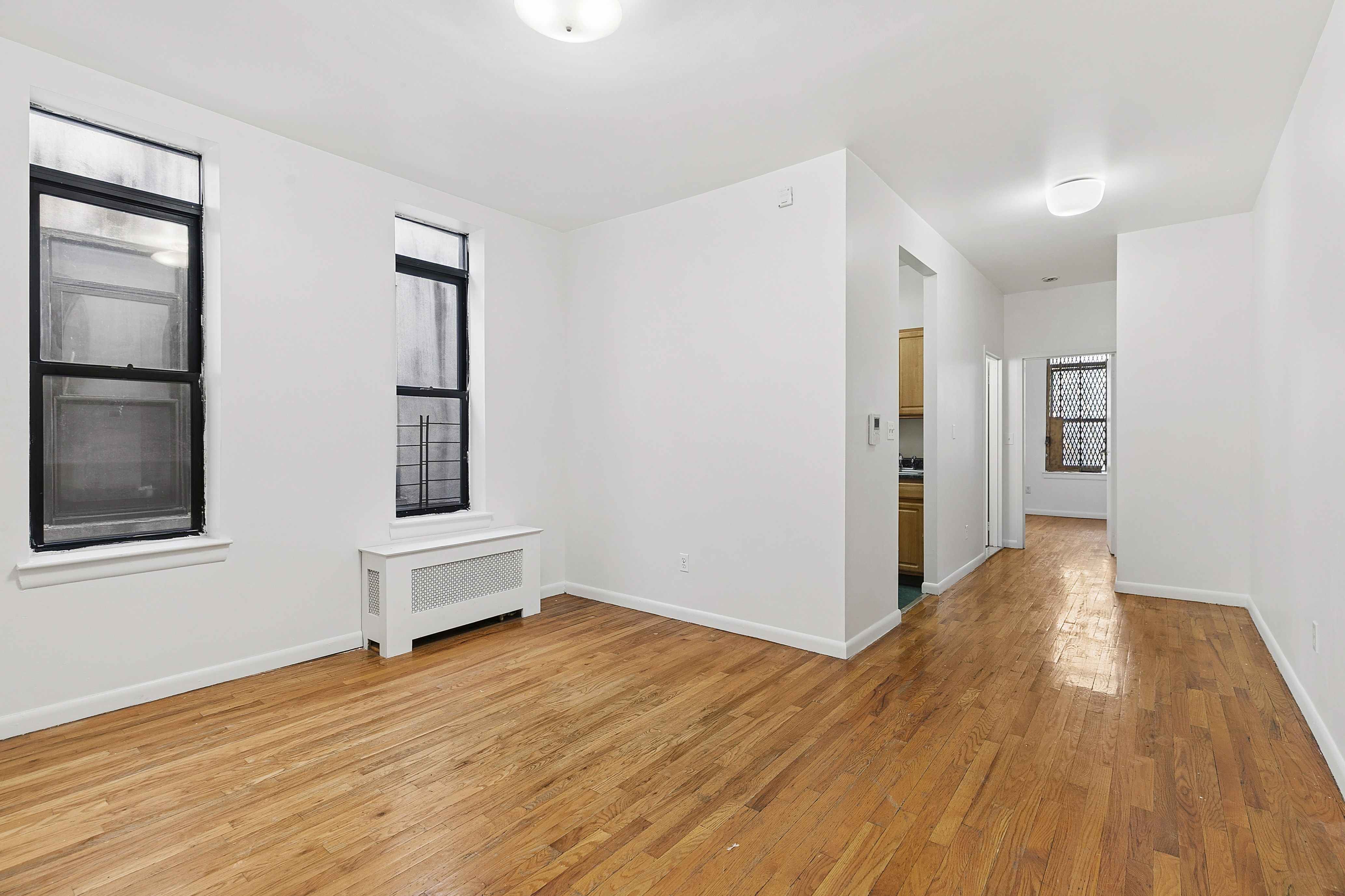 11 St Nicholas Avenue, Unit 5B Manhattan, NY 10026 - Photo 2 of 10 a view of empty room with wooden floor and window