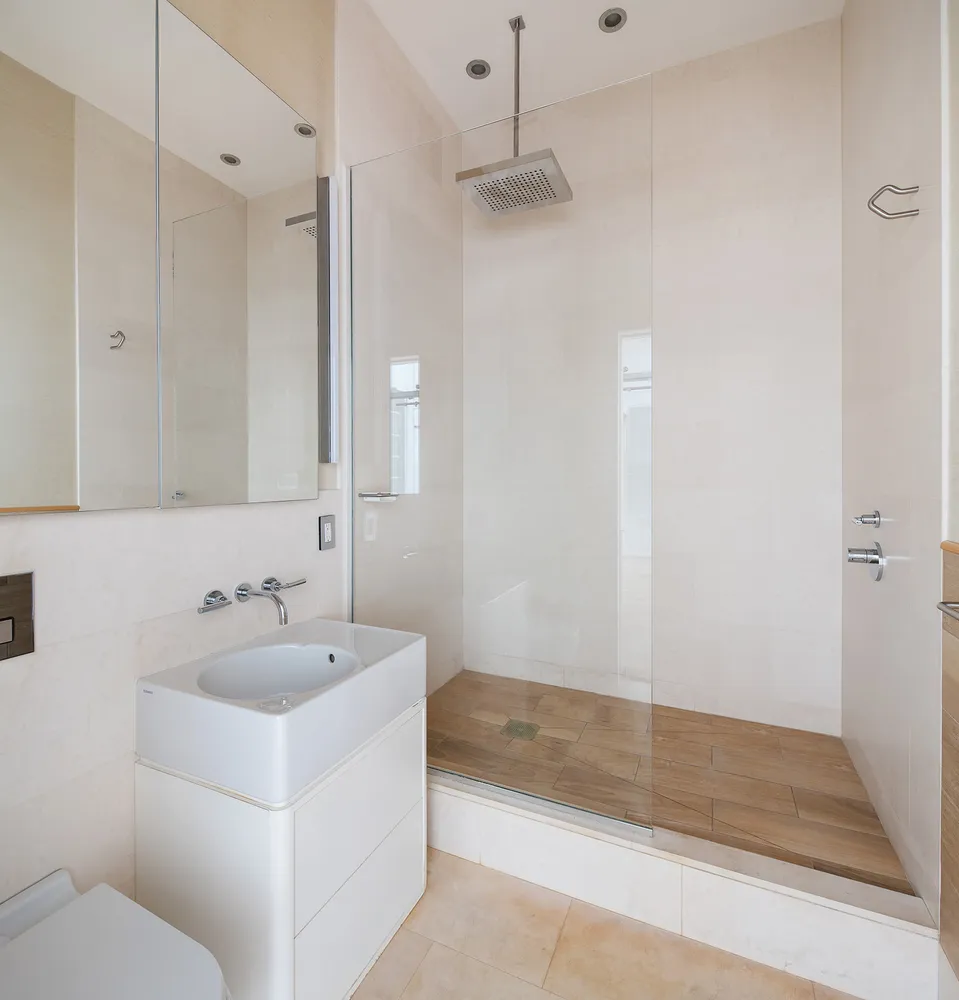 a bathroom with a sink a toilet and shower