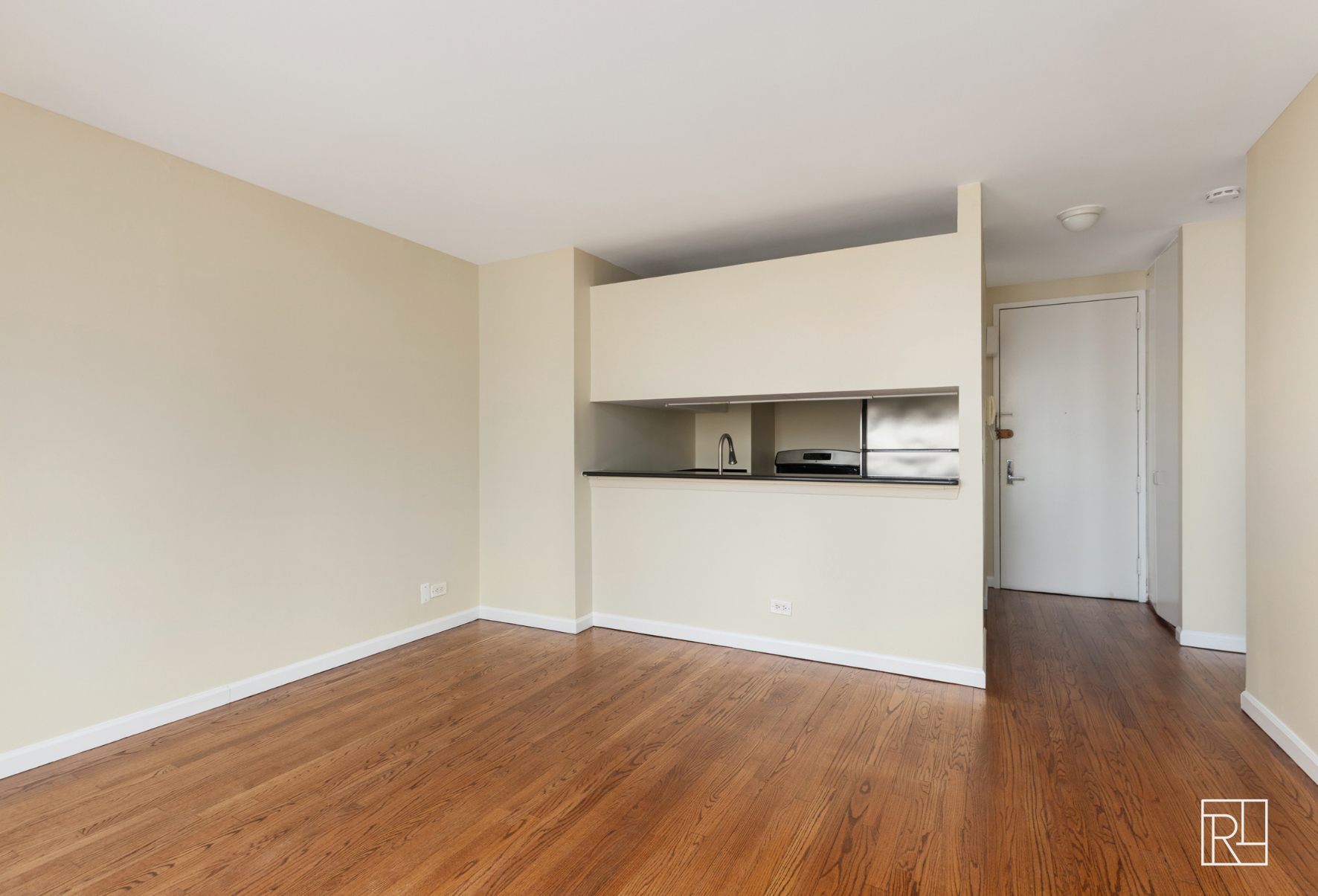 300 East 62nd Street, Unit 1501 Manhattan, NY 10065 - Photo 4 of 14 a view of a kitchen with wooden floor and cabinets