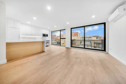 a view of an empty room with a stove and a large window