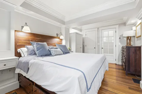 a spacious bedroom with a bed and wooden floor