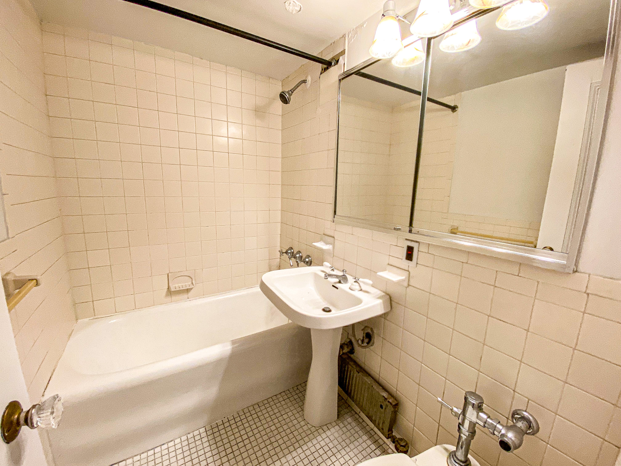 5 Tudor City Place, Unit 627 Manhattan, NY 10017 - Photo 7 of 11 a bathroom with a sink a toilet and shower