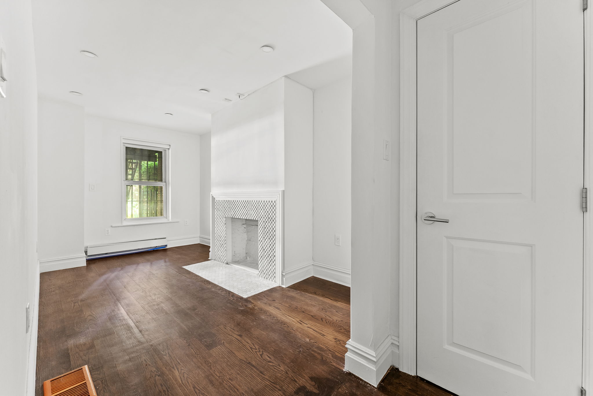 692 10th Street, Unit 1 Brooklyn, NY 11215 - Photo 4 of 12 an empty room with wooden floor fireplace and windows