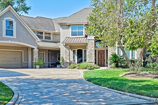 a front view of a house with yard and green space