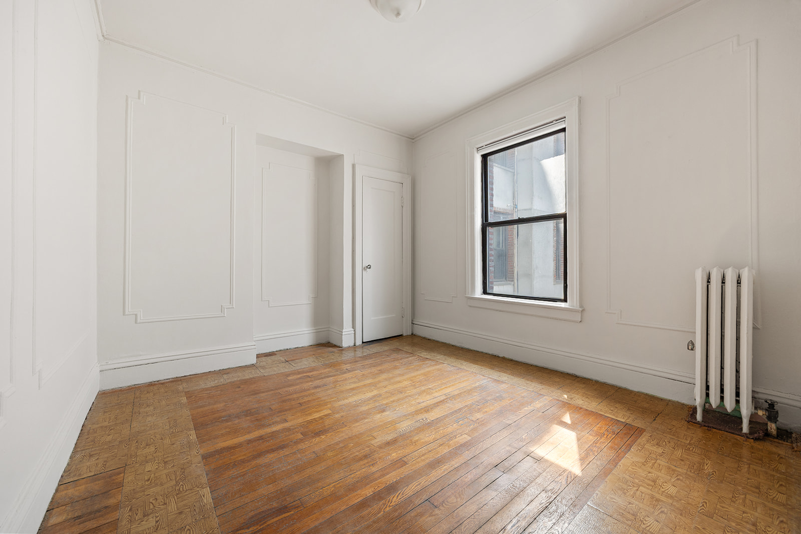 310 Windsor Place, Unit 32 Brooklyn, NY 11218 - Photo 10 of 19 a view of an empty room with wooden floor and a window