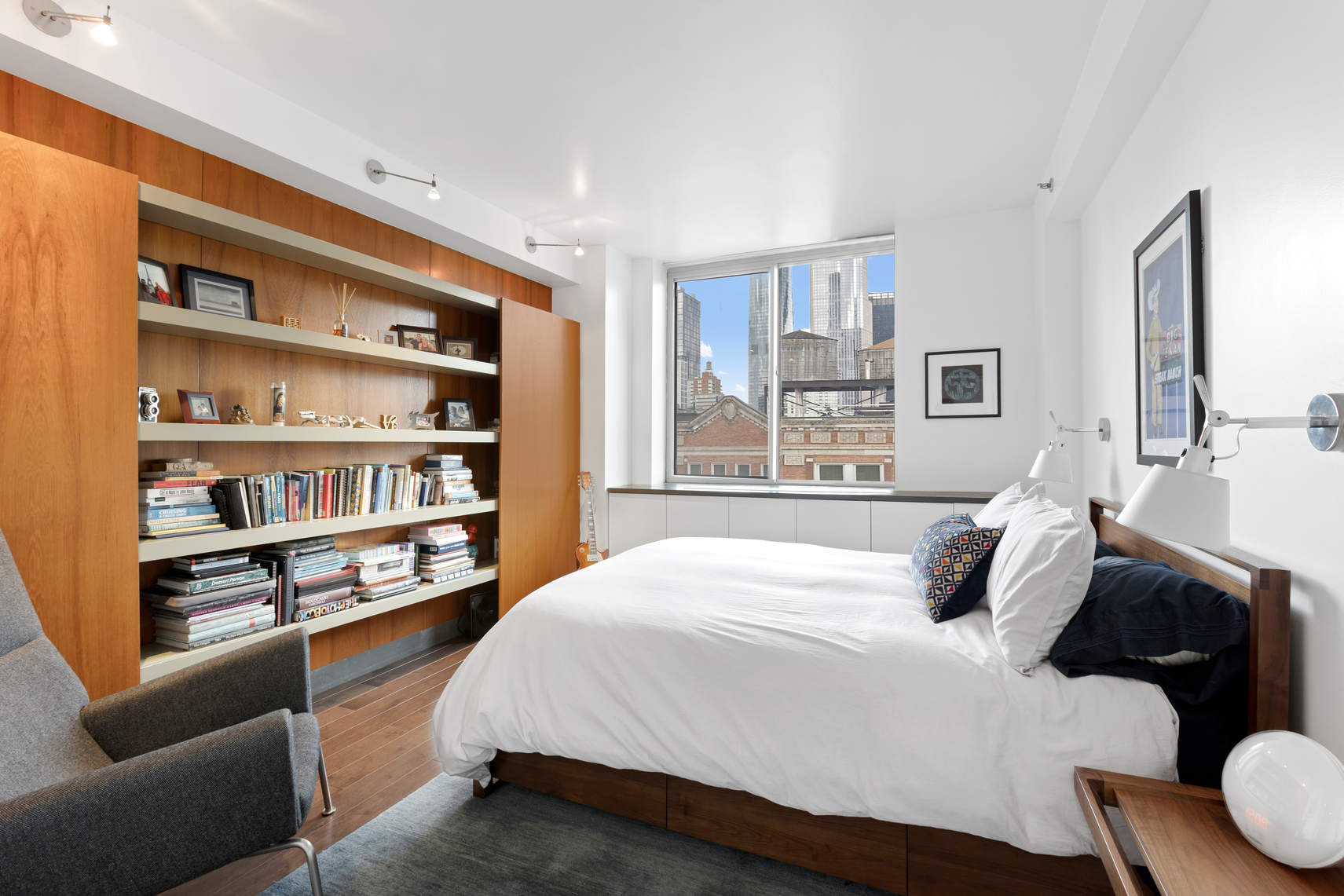 520 West 23rd Street, Unit PH16F Manhattan, NY 10011 - Photo 3 of 17 a bedroom with a bed a dresser and a book shelf