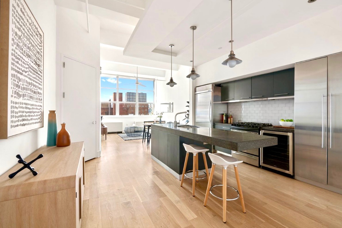 a kitchen with stainless steel appliances granite countertop a sink a stove and a wooden floors