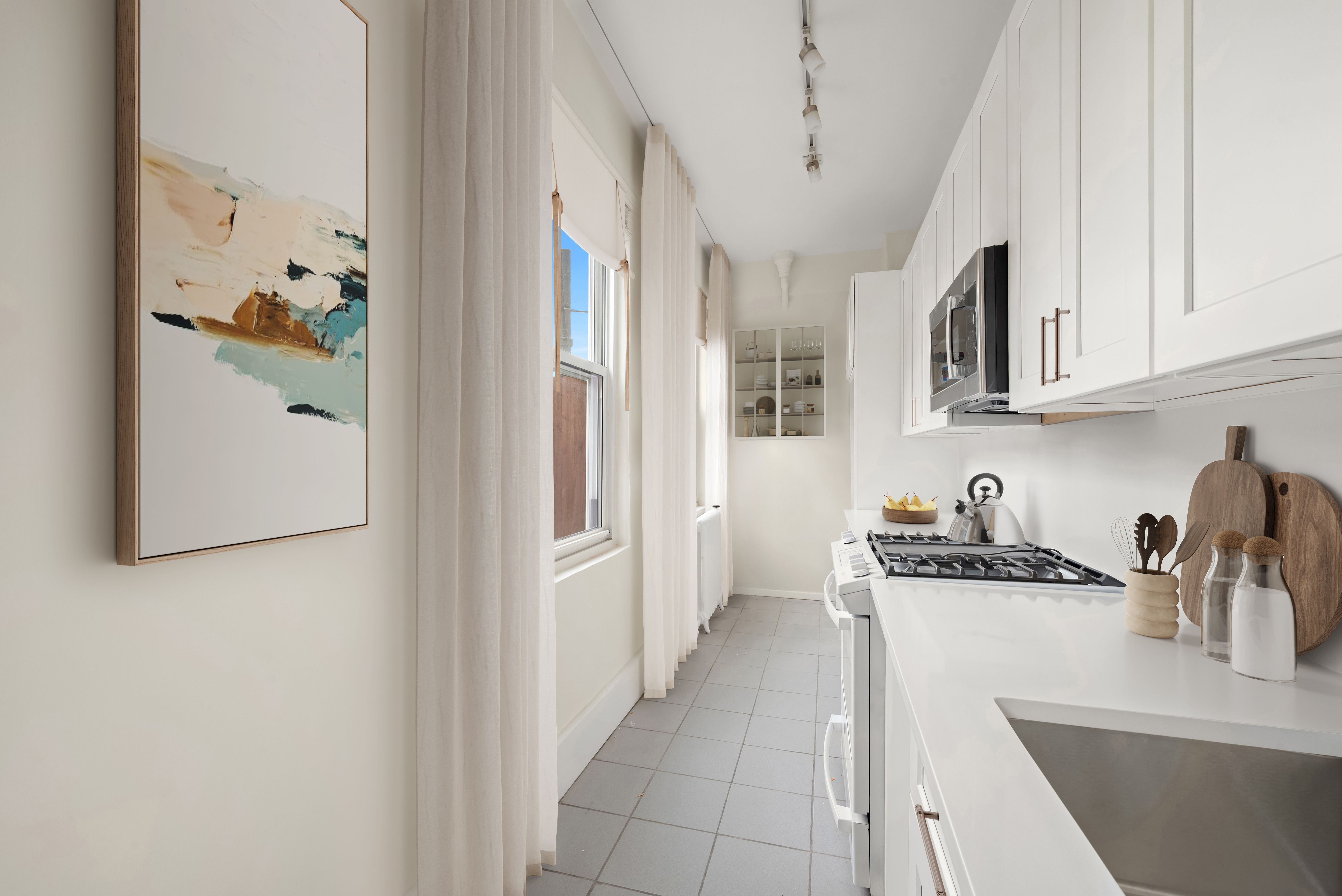 77 Park Avenue, Unit 16G Manhattan, NY 10016 - Photo 4 of 8 a kitchen with stainless steel appliances granite countertop a refrigerator and a sink