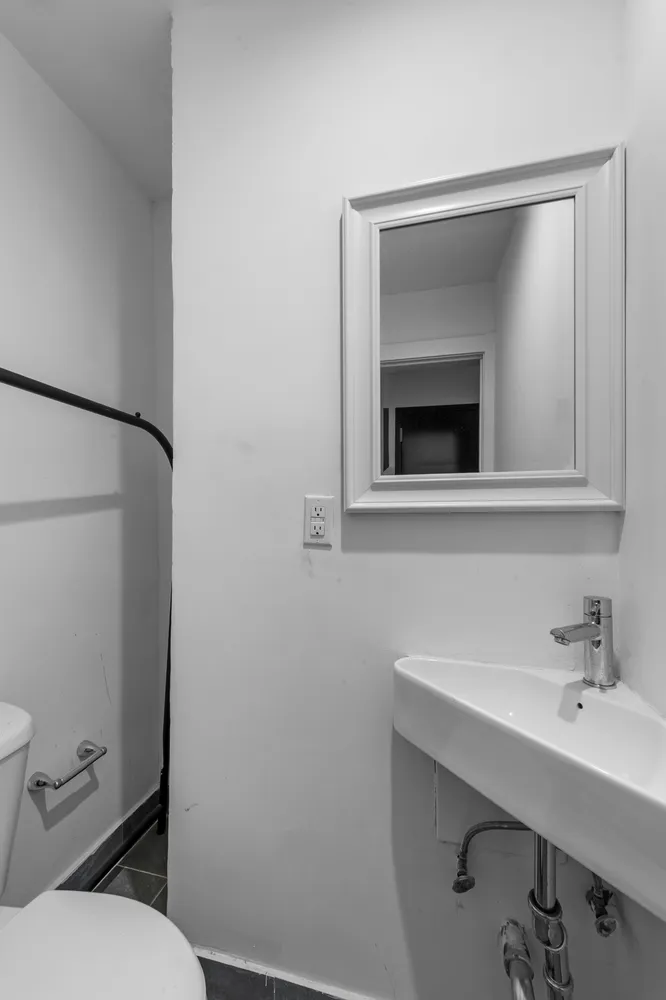 a bathroom with a toilet sink and mirror