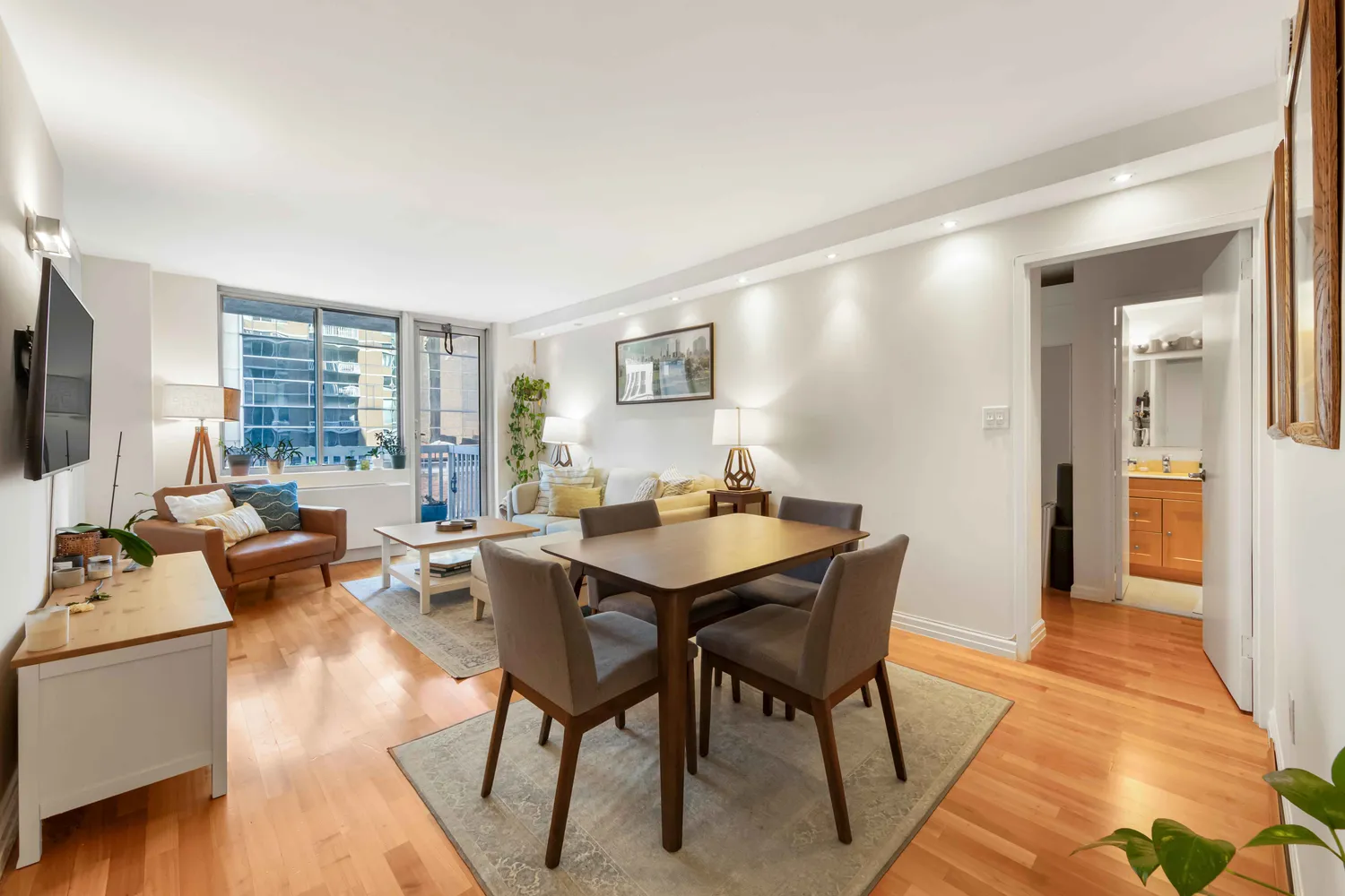a living room with furniture a flat screen tv and a large window