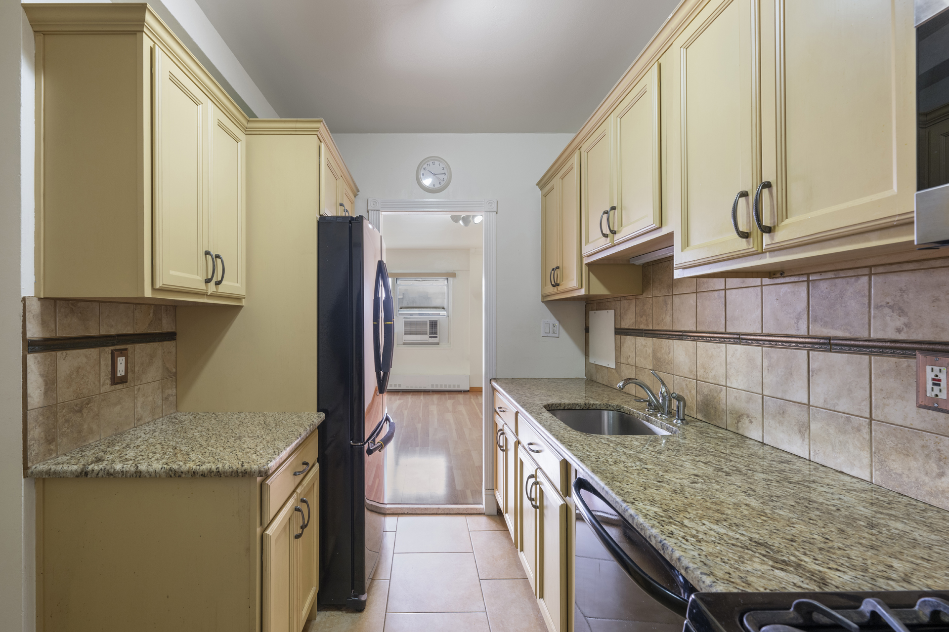 9 Fordham Hill Ovl, Unit 7H Bronx, NY 10468 - Photo 3 of 10 a kitchen with granite countertop a sink a stove and a wooden cabinets