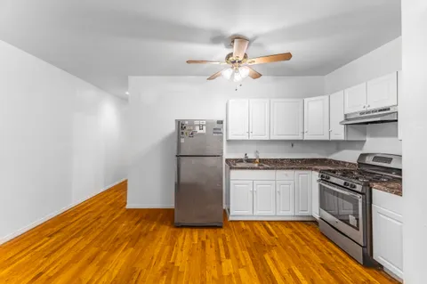 a kitchen with kitchen island granite countertop a stove a sink and a refrigerator