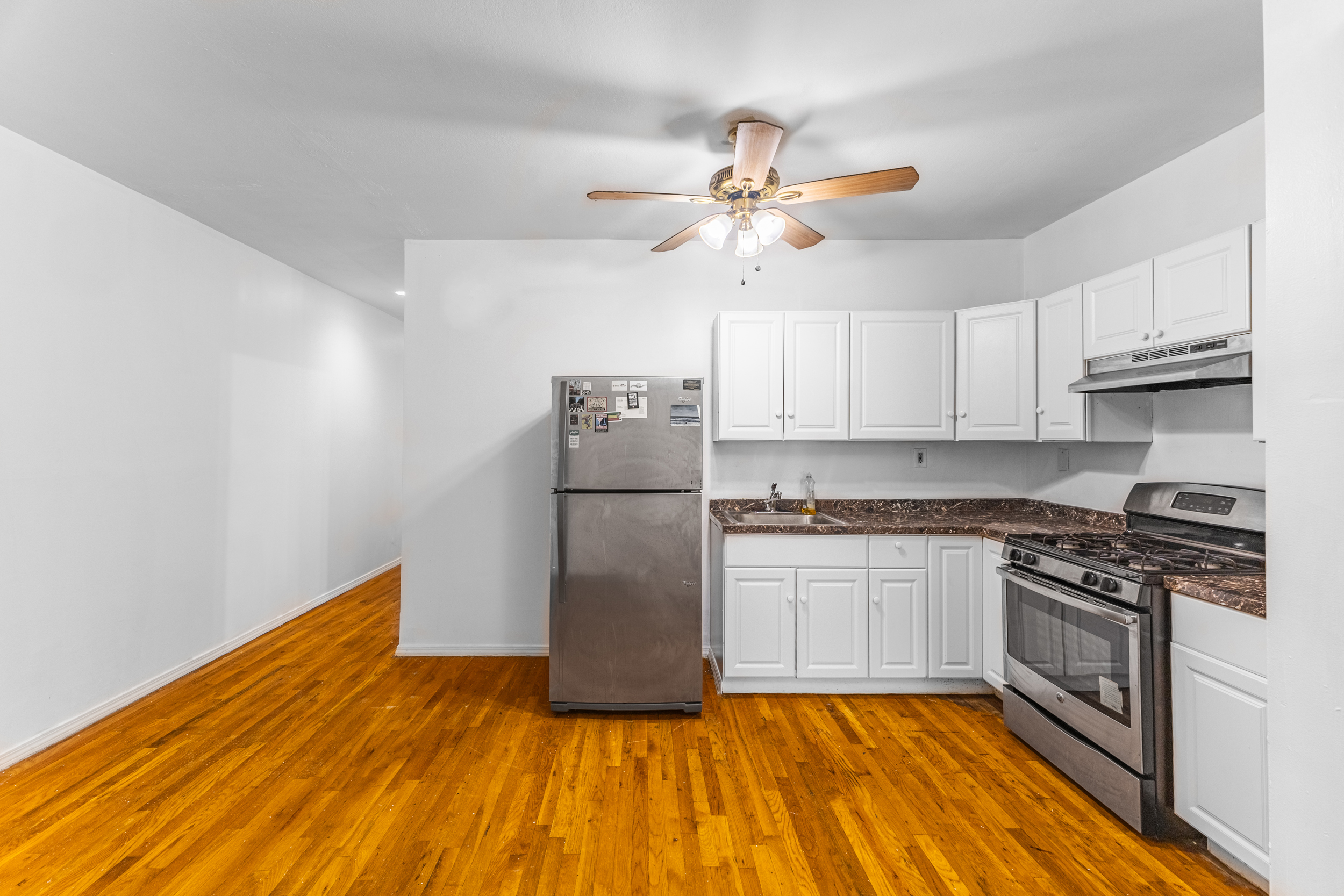434 Lexington Avenue Brooklyn, NY 11221 - Photo 10 of 22 a kitchen with kitchen island granite countertop a stove a sink and a refrigerator