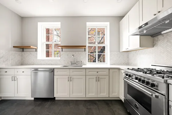 a kitchen with granite countertop white cabinets and a stove