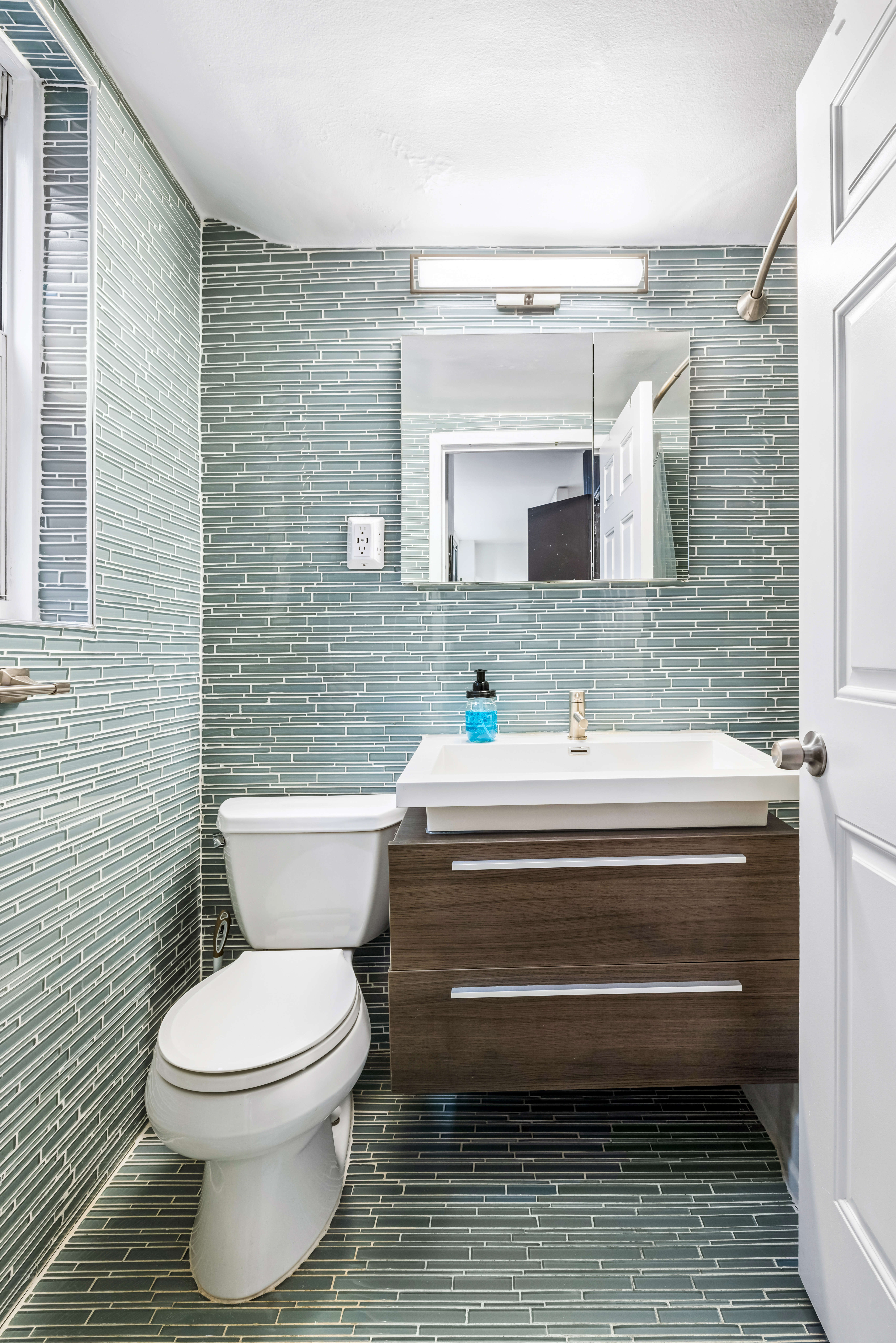 139 East 33rd Street, Unit 3M Manhattan, NY 10016 - Photo 6 of 11 a bathroom with a toilet a sink and mirror