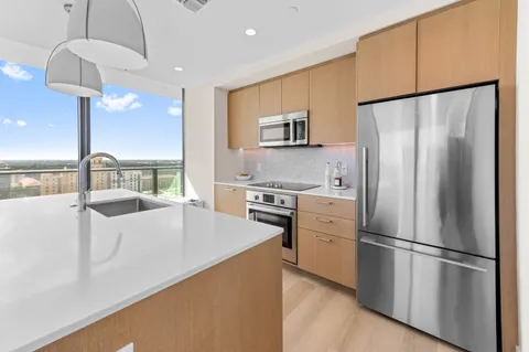 a kitchen with stainless steel appliances a refrigerator sink and stove
